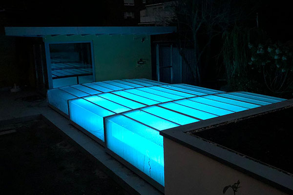Überdachter, beleuchteter Pool im Dunkeln